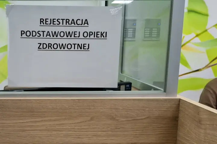 Tabliczka "Rejestracja Podstawowej Opieki Zdrowotnej" w poczekalni. Ubezpieczenie zdrowotne to podstawa.