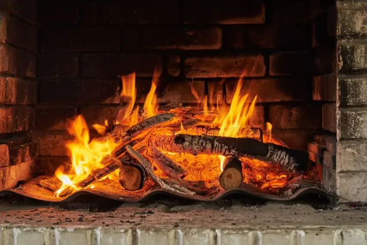 Un feu crépite dans une cheminée, réchauffant des morceaux de chêne bois de chauffage. Les flammes dansent joyeusement.
