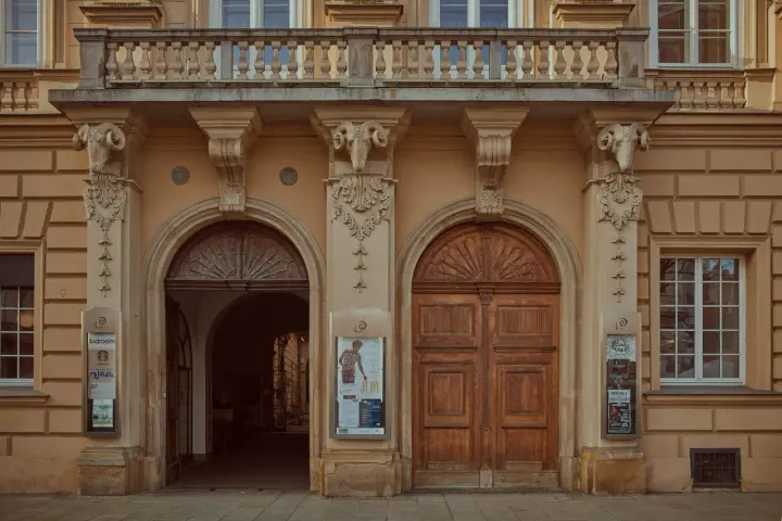 Kamienne głowy baranów zdobią fasadę, nad wejściem do piwnicy pod baranami historia czeka na odkrycie.