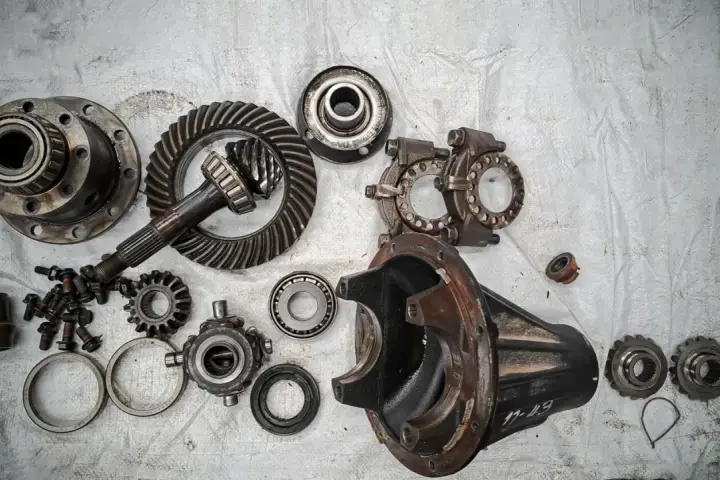 Rozłożony mechanizm różnicowy, gotowy do naprawy. Objawy awarii mogą być różne, od hałasu po problemy z jazdą.