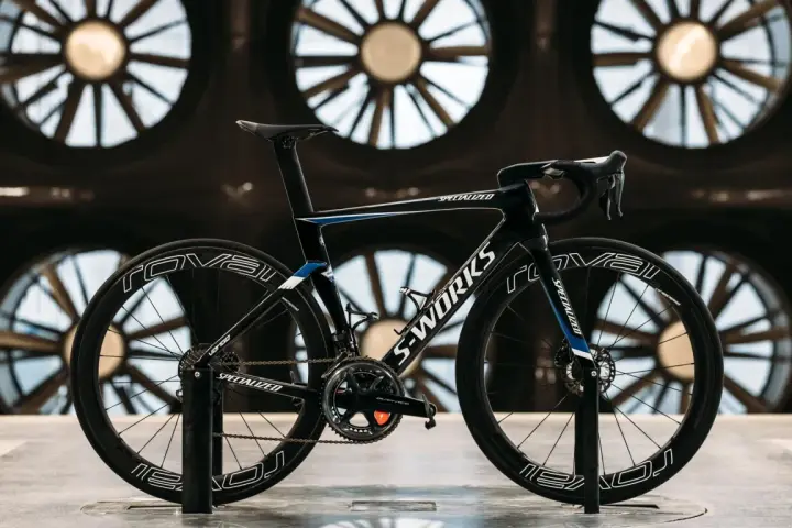 A black S-Works aero bike, designed for speed, is showcased in front of large industrial fans. This is what an aero bike looks like.