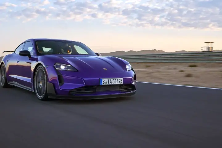 Fioletowe Porsche Taycan na torze wyścigowym podczas zachodu słońca.