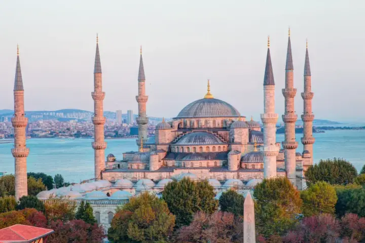 Błękitny Meczet w Stambule, z minaretami górującymi nad miastem i morzem. Czy Istambuł jest bezpieczny? Turyści spacerują pośród pięknej architektury.