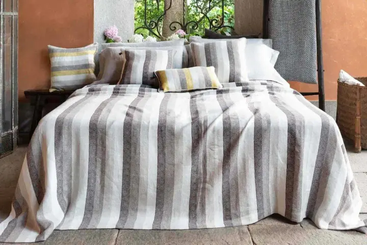 Letti a righe grigie e bianche, con cuscini coordinati. Un tocco di candeggina su lino bianco per un look fresco e moderno.
