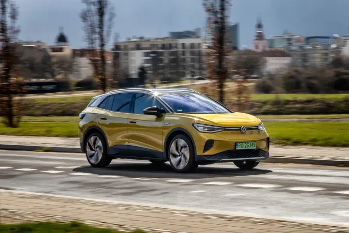 Żółty VW ID.4 jedzie po mieście, pokazując swój imponujący zasięg.
