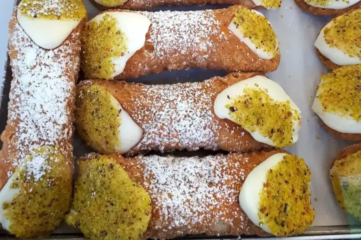 Chrupiące rurki wypełnione kremem i posypane pistacjami. Te pyszne **cannoli** wyglądają jak dzieła sztuki cukierniczej.