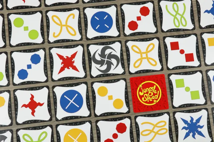 Carte di Jungle Speed con simboli colorati. Le regole del gioco sono semplici: trova le coppie di simboli identici per vincere.