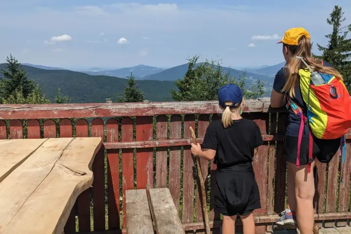 Dwie dziewczynki podziwiają malownicze widoki z tarasu. To idealne miejsce na odkrywanie widokowych szlaków blisko Krakowa.