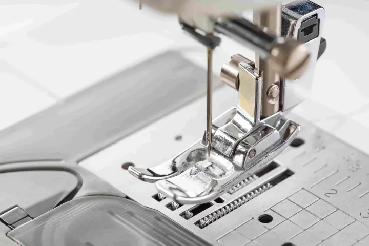 Primer plano del prensatelas de una máquina de coser, listo para guiar la tela con precisión.