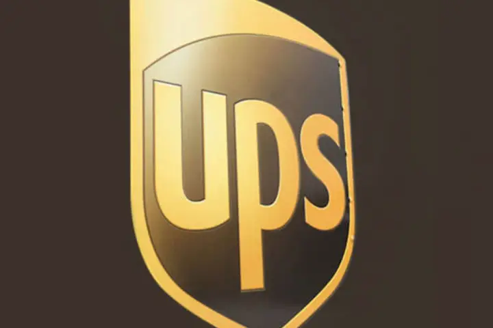 Logo UPS dorato su sfondo scuro. Informazioni sullo stipendio corriere UPS.