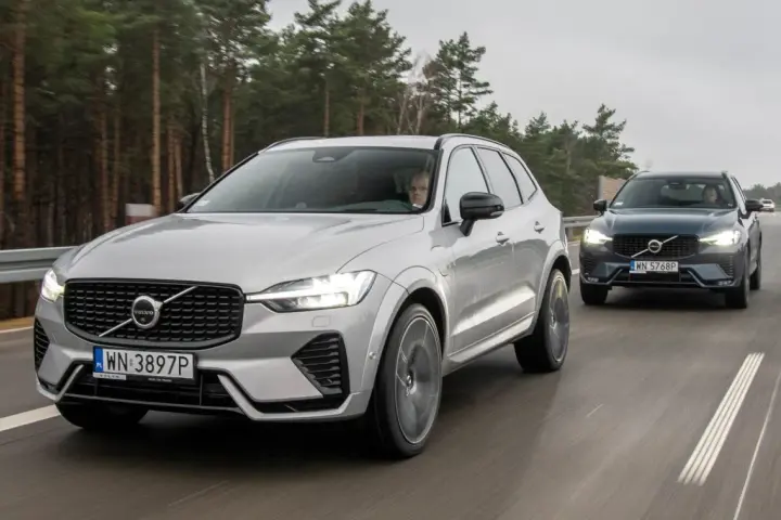 Dwa Volvo XC60 T8 jadące po drodze leśnej. Jeden srebrny, drugi ciemnoszary.