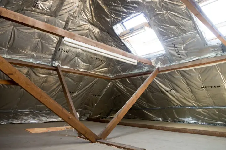 Isolation des combles : le prix au m2 dépend de la technique. Vue d'un grenier en cours d'isolation avec matériaux réfléchissants.