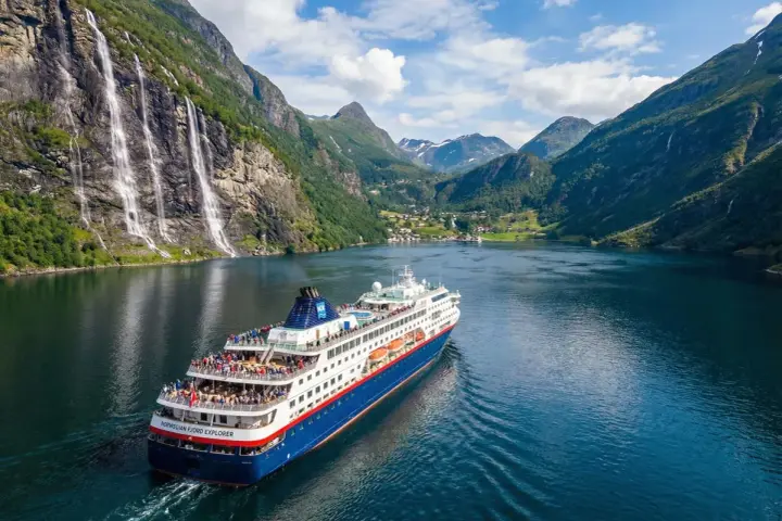 Statek wycieczkowy "Norwegian Fjord Explorer" płynie przez malowniczy fiord. To idealny sposób, by zobaczyć, co można przewieźć do Norwegii – zapierające dech w piersiach krajobrazy!