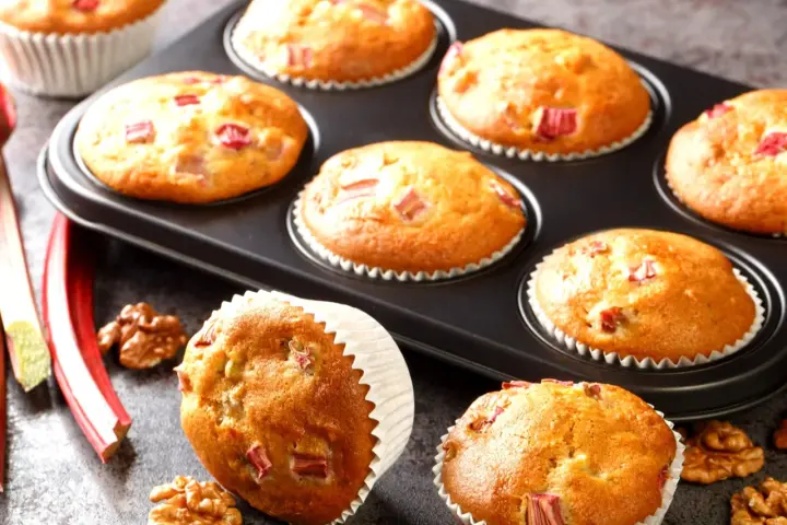 Pyszne muffinki z rabarbarem, świeżo upieczone, z kawałkami rabarbaru i orzechami włoskimi.