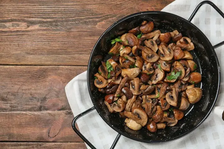 Funghi in padella, dorati e profumati, pronti per essere gustati.