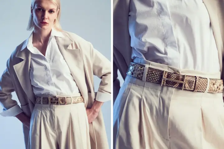 Modello indossa una cintura in pelle di serpente, un accessorio di tendenza che completa un look elegante con pantaloni beige e blazer.