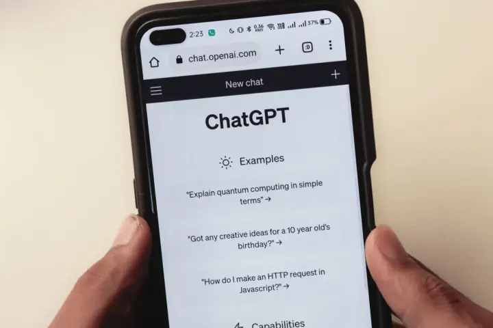 Na ekranie smartfona widać interfejs ChatGPT, gdzie użytkownik może zadawać pytania, np. o komputery kwantowe.