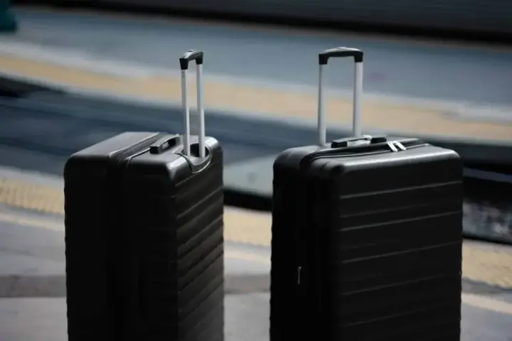 Dwa czarne walizki, idealne jako bagaż podręczny Ryanair, czekają na podróż.