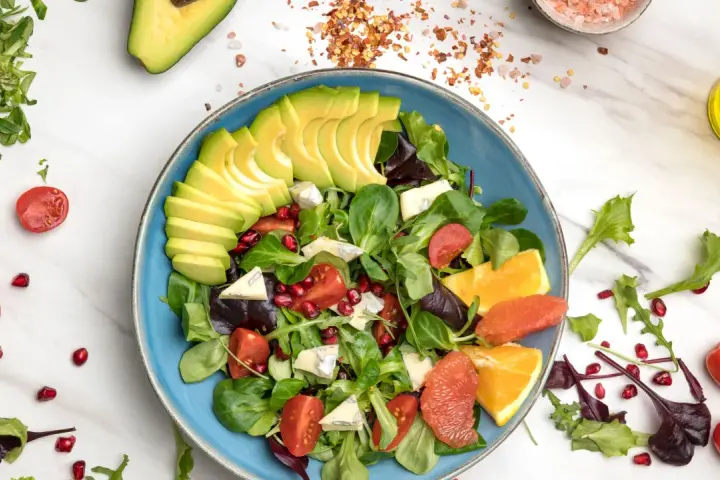 Insalata di avocado fresca con pomodorini, melograno, agrumi e formaggio blu.