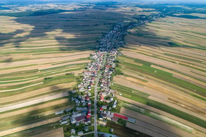 Długa wieś w Polsce, otoczona polami o różnych kolorach, tworząca mozaikę krajobrazu. Może to najpiękniejsza wieś w Polsce?