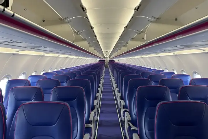 Puste fioletowe siedzenia w samolocie Wizz Air.