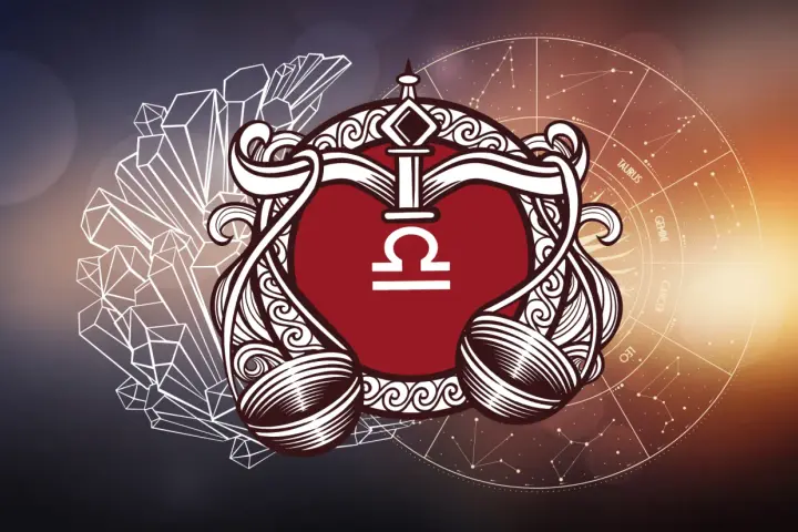 Symbol wagi (23.09-22.10) w ozdobnej ramie, otoczony kryształami i kołem zodiaku.