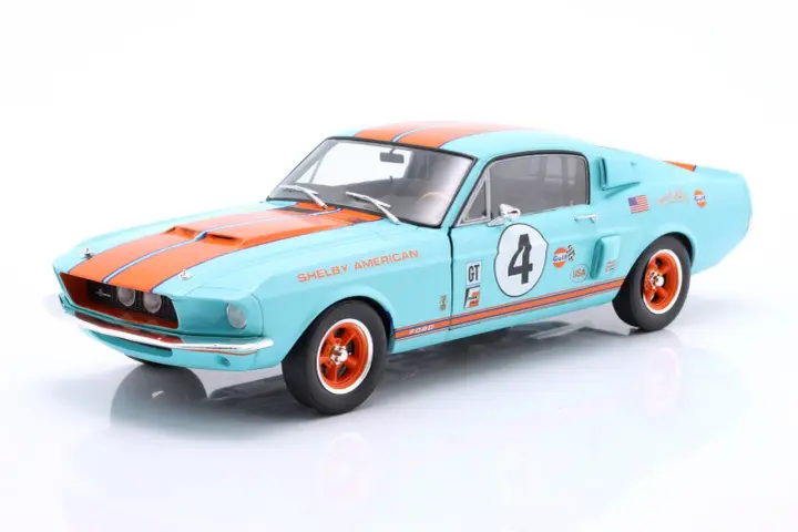 Błękitny Shelby GT z pomarańczowymi pasami i numerem 4, ozdobiony logotypami Gulf i USA.