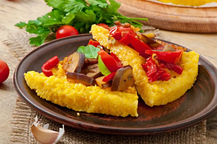 Polenta z czym jeść? Podana z duszonymi warzywami: papryką, bakłażanem i pomidorami. Pyszny pomysł na obiad!