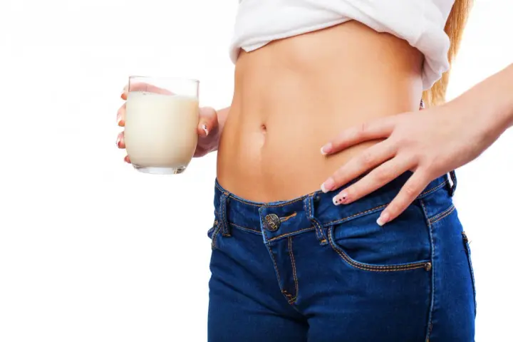Donna con bicchiere di latte, un aiuto per sapere cosa bere la sera per andare di corpo.