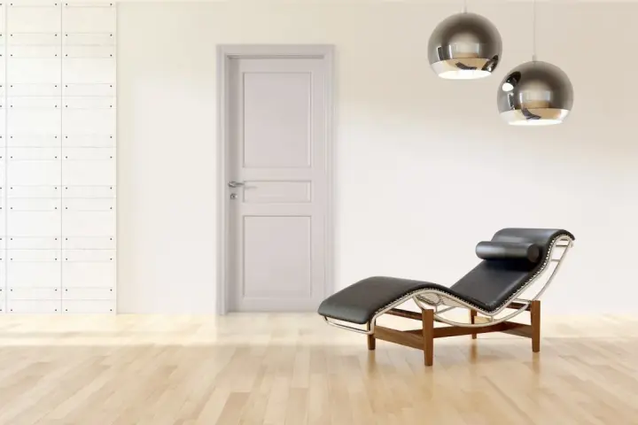 Divano in pelle nera e metallo, con un'elegante porta tortora e un muro con texture geometrica. Un perfetto abbinamento tortora e verde per un ambiente moderno.