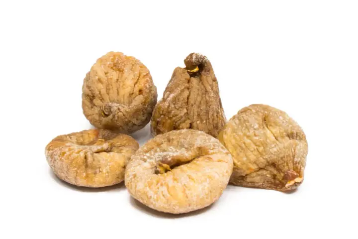 Fünf getrocknete Feigen, die zeigen, wie gesund Feigen sind. Sie sind leicht mit Zucker bestäubt und liegen auf weißem Hintergrund.