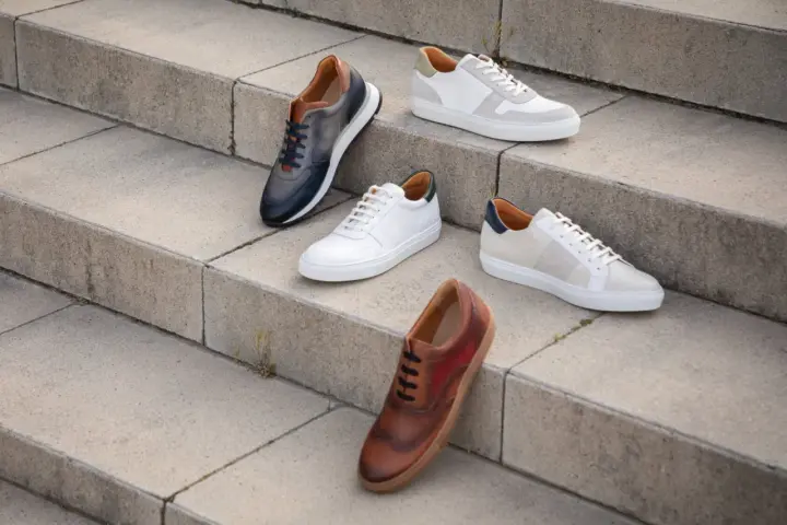 Cinque paia di scarpe eleganti, perfette per un outfit ufficio sneakers. Diverse tonalità di pelle e design moderni.