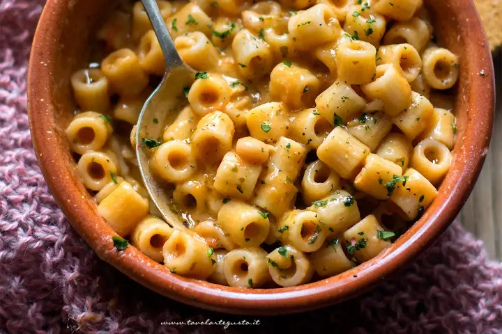 Un piatto fumante di pasta e fagioli, con ditalini e fagioli borlotti in un sugo cremoso, guarnito con prezzemolo tritato.