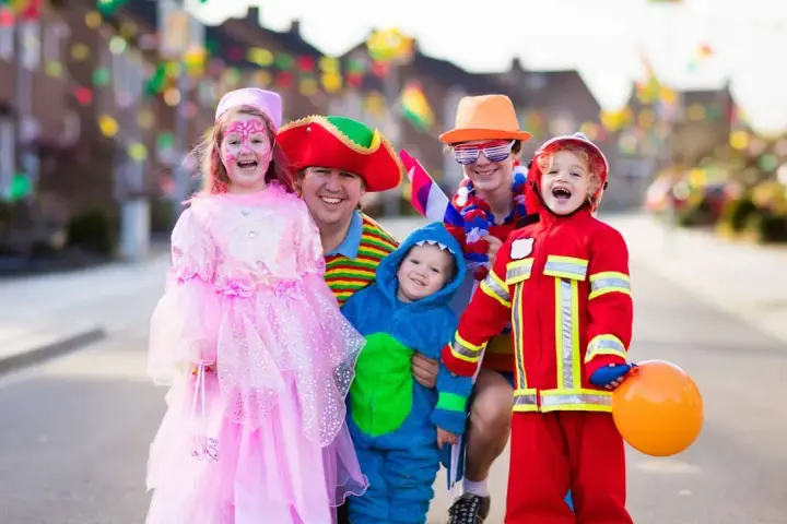 Fröhliche Familie in Kostümen feiert Fasching. Wann sind Faschingsferien in Baden-Württemberg 2026?