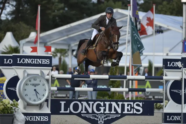 Le cavalier Cooper van de Heffinck et son cheval sautent un obstacle lors d'une compétition équestre.