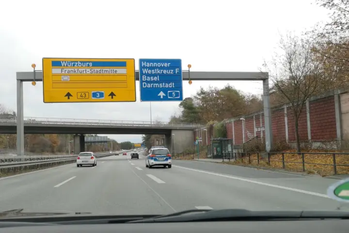 Autostrada A5. Znaki kierują do Würzburga, Frankfurtu, Hanoweru i Darmstadt. Na drodze ruch samochodowy.