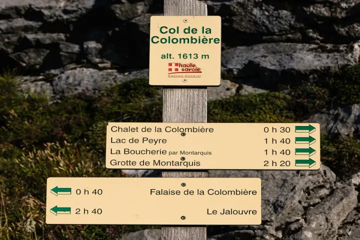 Panneau indicateur au Col de la Colombière (alt. 1613m), indiquant des sentiers et leurs temps de parcours. Un dénivelé est la différence d'altitude entre deux points.
