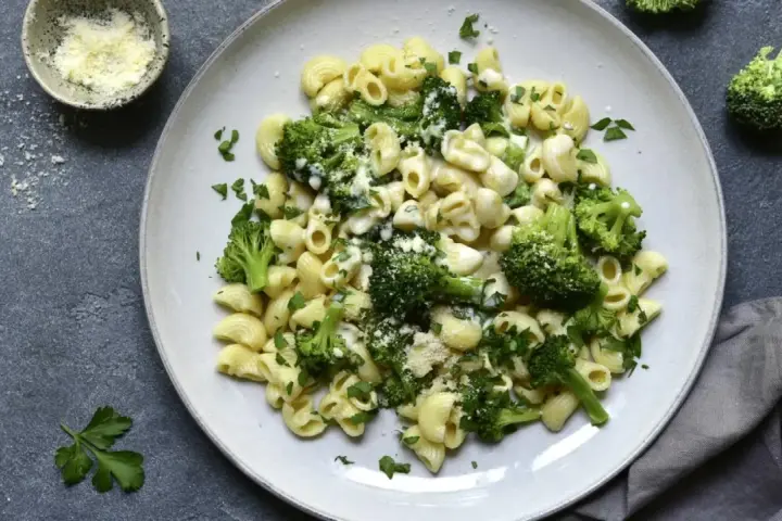 Pasta con brócoli cremosa, espolvoreada con queso rallado y perejil fresco. Un plato sencillo y delicioso.
