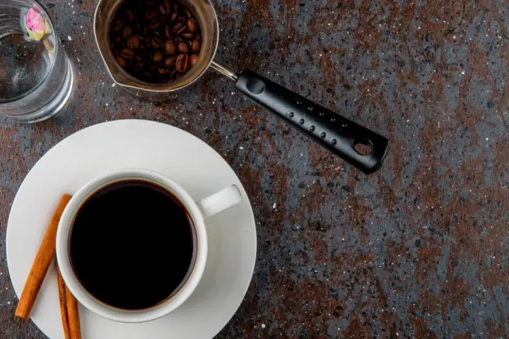 Jak zrobić americano: gorąca woda, espresso i ziarna kawy. Idealny napój na chłodny poranek.