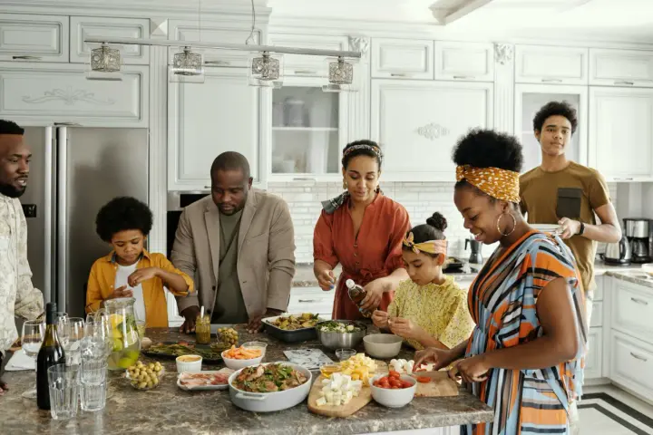 Une famille prépare un repas ensemble, partageant des moments précieux. Les ingrédients sont disposés sur le comptoir, comme un trésor **réduit aux acquets** de leur amour.