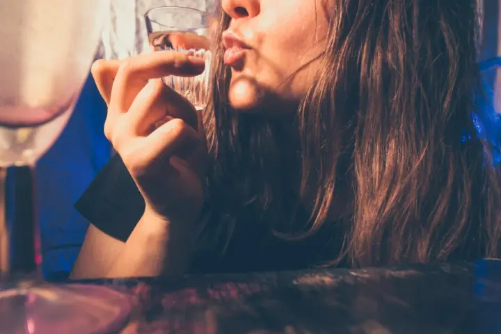 Młoda osoba pije alkohol. Pamiętaj, co grozi za picie alkoholu w wieku 17 lat: problemy zdrowotne i prawne.