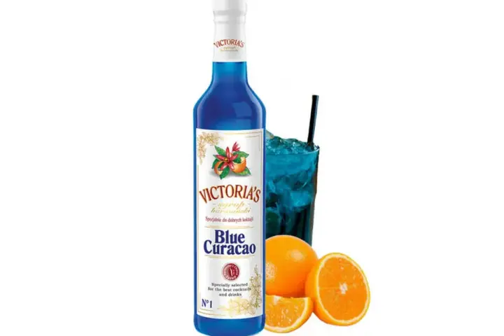 Niebieski syrop Blue Curacao Victoria's, idealny do drinków z Malibu i orzeźwiających koktajli. Obok szklanka z lodem i napojem.