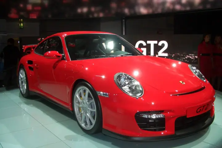 Czerwony Porsche 997 GT2 błyszczy na wystawie, gotowy do jazdy.