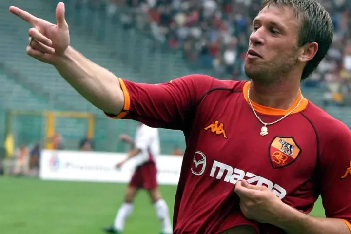 Antonio Cassano w koszulce Romy, z palcem wskazującym w górę, celebruje bramkę.