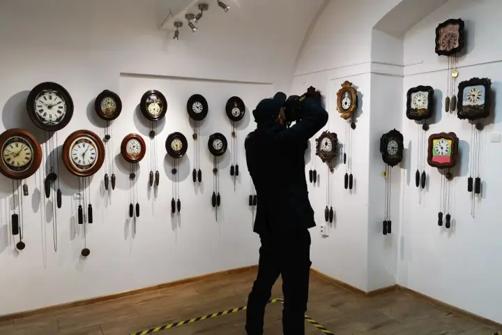 Odwiedzający dokumentuje bogactwo kolekcji największego muzeum zegarów w Polsce, gdzie wiszą dziesiątki zabytkowych czasomierzy.