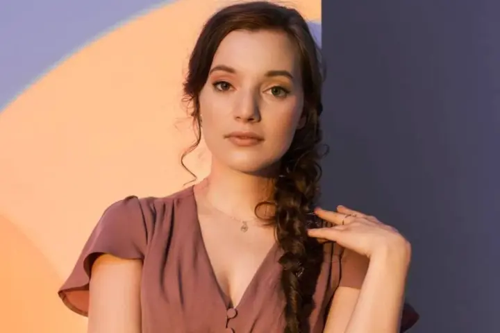 Sanah w The Voice of Poland przesłuchania. Młoda artystka w różowej sukience z warkoczem.