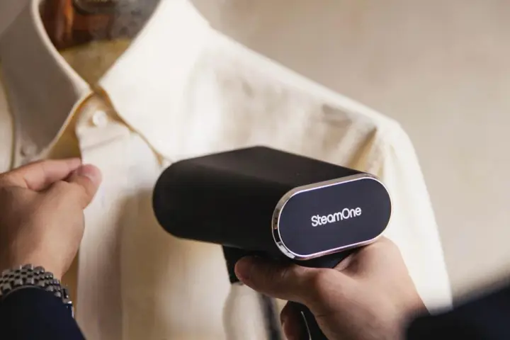 Un colpo di vapore dal ferro da stiro SteamOne elimina le pieghe da una camicia chiara.