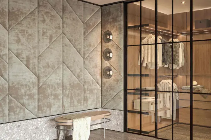 Ingresso con boiserie moderne imbottite, panchina in legno e rattan, e cabina armadio a vista con illuminazione integrata.