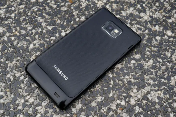 Czarny Samsung Galaxy S2 leży na kamienistej nawierzchni.