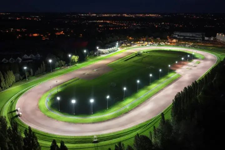 Vue aérienne d'un hippodrome illuminé la nuit, rappelant le nombre d'hippodrome en France.